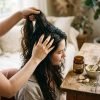Manos_aplicando_aceite_en_cabello_202608270110